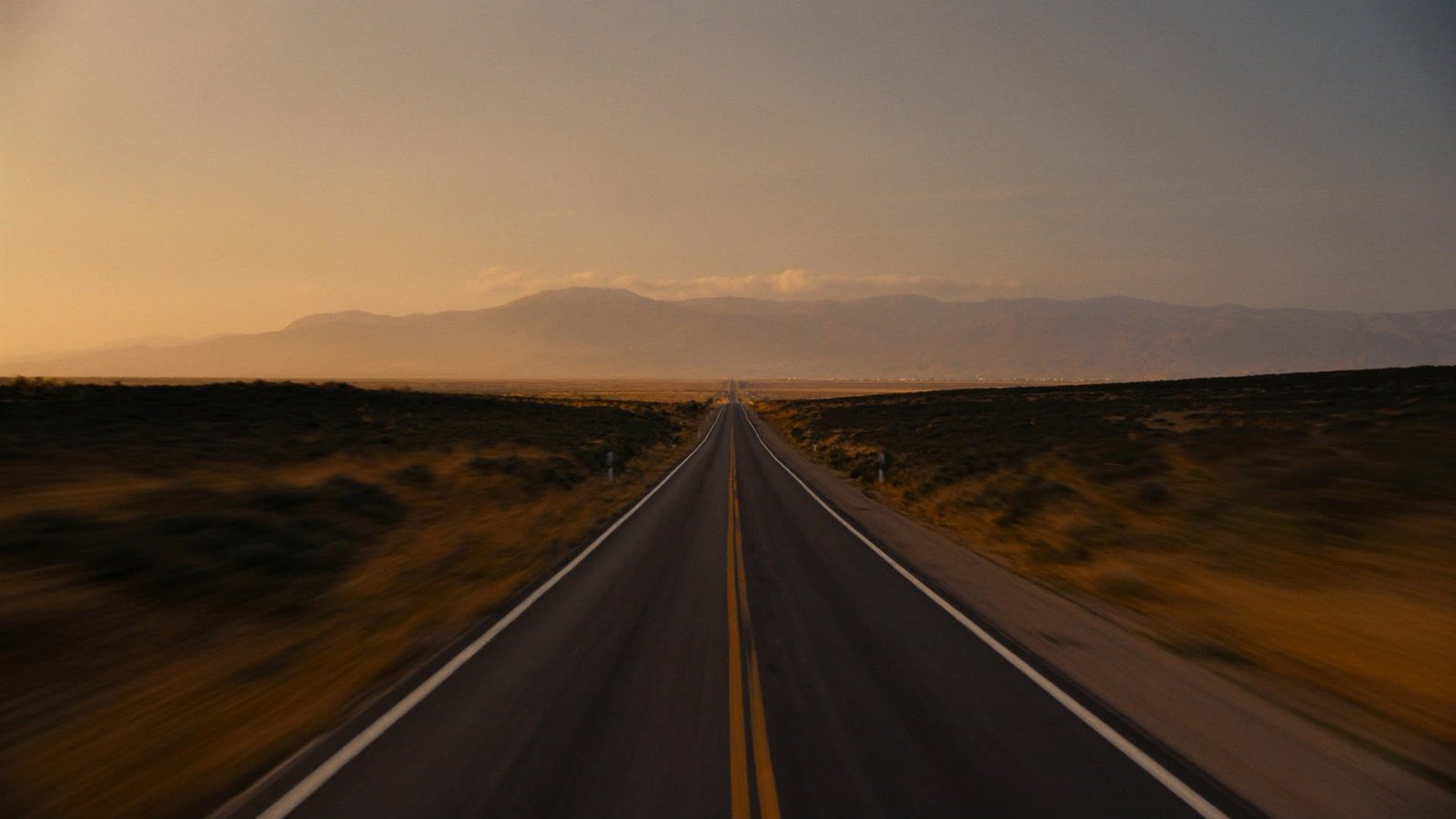 The road leaving Agadir toward distant mountains in warm morning light
