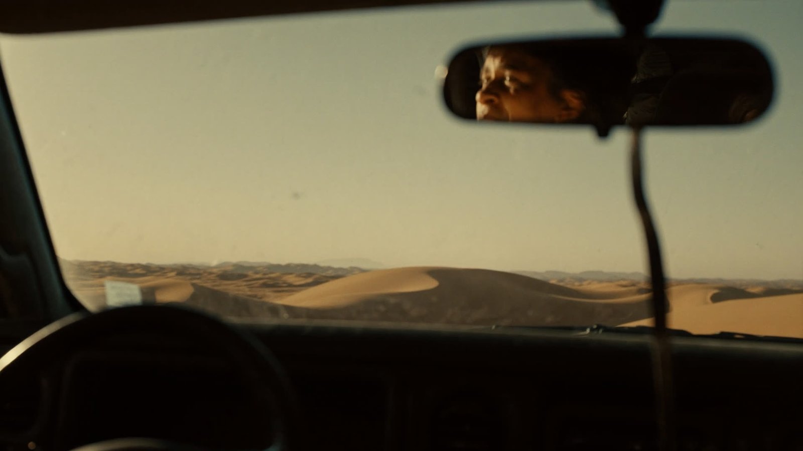 First glimpse of the Erg Chegaga dunes through the dusty windshield of a 4x4