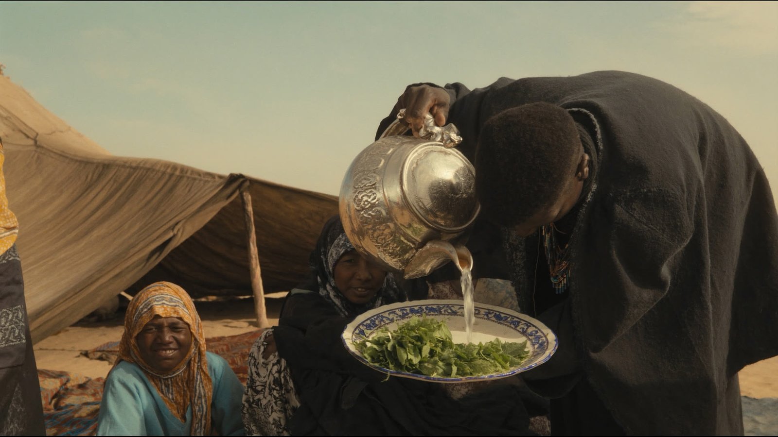 Tea being poured at a nomadic family's tent in the desert